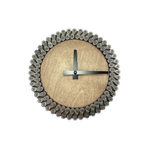 May include: A round wooden clock with black hands and a silver bicycle chain border.