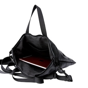 May include: A black leather laptop bag with a zippered closure and a long adjustable strap. The bag is open and a tablet is inside.