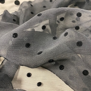 May include: Black sheer fabric with black velvet polka dots.