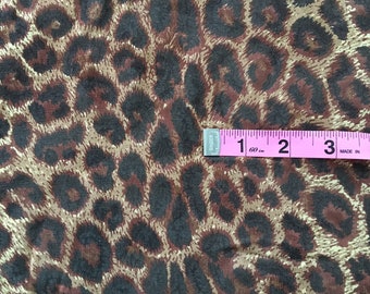 May include: Brown and gold leopard print fabric with a measuring tape showing 1 inch, 2 inches, and 3 inches.