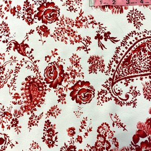 May include: White fabric with a red floral pattern. The pattern includes small flowers, larger roses, and paisley shapes. A measuring tape is visible in the top right corner of the image. The tape reads "60", "1", "2", "3", "4", "Made in China".
