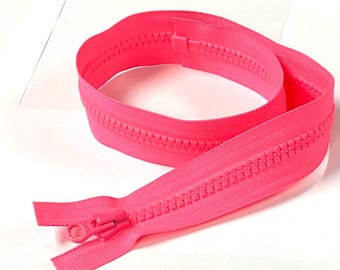 Puede incluir: Una cremallera de plástico de color rosa neón brillante que cuenta con un cursor y un tirador a juego. La cinta de la cremallera es de tela tejida y los dientes son de plástico moldeado, dispuestos en una bobina continua en forma circular.