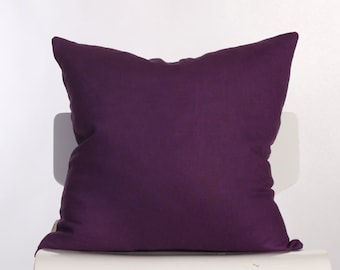May include: A deep purple square pillow on a white chair.