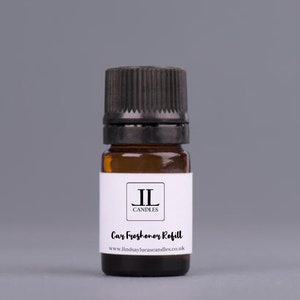 May include: A small brown glass bottle with a black cap and a white label. The label says "JL Candles" and "Car Freshener Refill" with the website address "www.lindsaylucascandles.co.uk".