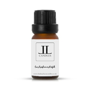 May include: A small brown glass bottle with a black lid. The bottle is labelled with the text "JL Candles" and "Car Freshener Refill". The website address "www.lindsaylucascandles.co.uk" is printed on the label.