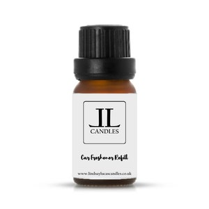 May include: A small brown glass bottle with a black lid. The bottle is labelled with the text "JL Candles" and "Car Freshener Refill". The website address "www.lindsaylucascandles.co.uk" is printed on the label.