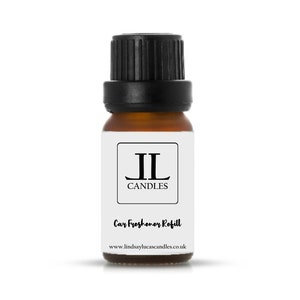 May include: A small brown glass bottle with a black lid. The bottle is labelled with the text "JL Candles" and "Car Freshener Refill". The website address "www.lindsaylucascandles.co.uk" is printed on the label.