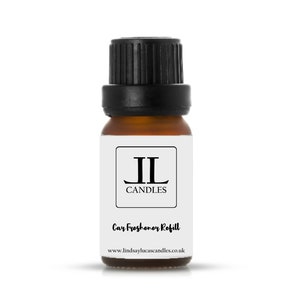 May include: A small brown glass bottle with a black lid. The bottle is labelled with the text "JL Candles" and "Car Freshener Refill". The website address "www.lindsaylucascandles.co.uk" is printed on the label.