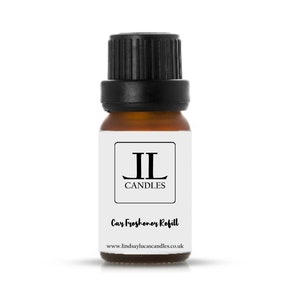 May include: A small brown glass bottle with a black lid. The bottle is labelled with the text "JL Candles" and "Car Freshener Refill". The website address "www.lindsaylucascandles.co.uk" is printed on the label.