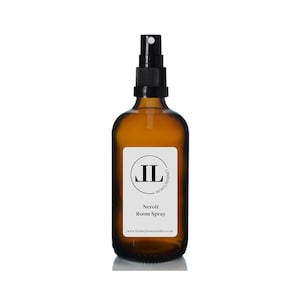 May include: A brown glass bottle with a black spray nozzle. The bottle has a white label with the text "Lindsay Luce's Scent Library" and "Neroli Room Spray" and the website address "www.lindsaylucescandles.co.uk".