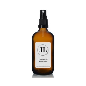 May include: A brown glass bottle with a black spray nozzle and a white label. The label has a black circle with the letters "IL" inside. The text on the label reads "Lindsay Louces - Scent Inspired", "Pumpkin Pie Room Spray", and "www.lindsayloucescandles.co.uk".