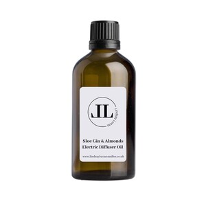 Könnte beinhalten: Eine braune Glasflasche mit schwarzem Deckel und einem weißen Etikett. Das Etikett enthält einen schwarzen Kreis mit den Buchstaben "JL" darin. Der Text auf dem Etikett lautet "Slo Gin & Almonds Electric Diffuser Oil" und "www.lindsaylucascandles.co.uk".