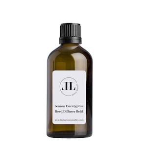 Op de afbeelding: Een bruine glazen fles met een zwarte dop en een wit etiket. Het etiket heeft een zwarte cirkel met de letters "JL" erin. De tekst op het etiket luidt "Lemon Eucalyptus Reed Diffuser Refill" en "www.lindsaylucascandles.co.uk".