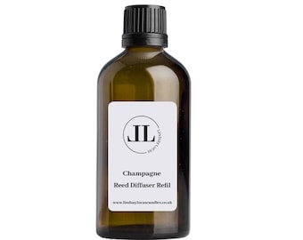 May include: A brown glass bottle with a black cap and a white label. The label has a circle with the letters "JL" inside and the text "Champagne Reed Diffuser Refill" and "www.lindsaylucascandles.co.uk".