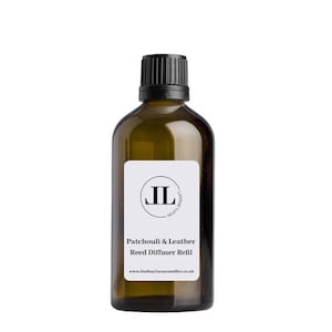 May include: A brown glass bottle with a black lid and a white label. The label has a black circle with the letters "JL" in white. The text on the label reads "Patchouli & Leather Reed Diffuser Refill" and "www.lindsaylucascandles.co.uk".