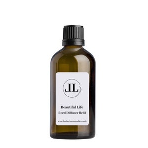 May include: A brown glass bottle with a black lid and a white label. The label has a black circle with the letters "JL" inside. The text on the label reads "Beautiful Life Reed Diffuser Refill" and "www.lindsaylucascandles.co.uk".