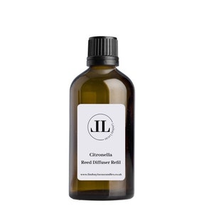 Könnte beinhalten: Eine braune Glasflasche mit schwarzem Verschluss und weißem Etikett. Auf dem Etikett steht "Citronella Reed Diffuser Refill" mit dem Markenlogo "JL Lindsay Lucas Candles". Die Flasche enthält eine klare Flüssigkeit.