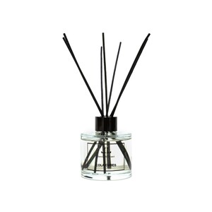 Puede incluir: Un difusor de aroma en botella de vidrio transparente con cañas negras y una tapa negra. La botella tiene una etiqueta que dice "Reed Diffuser" y "COLA CUBES".