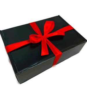 May include: A black gift box with a red ribbon tied in a bow.