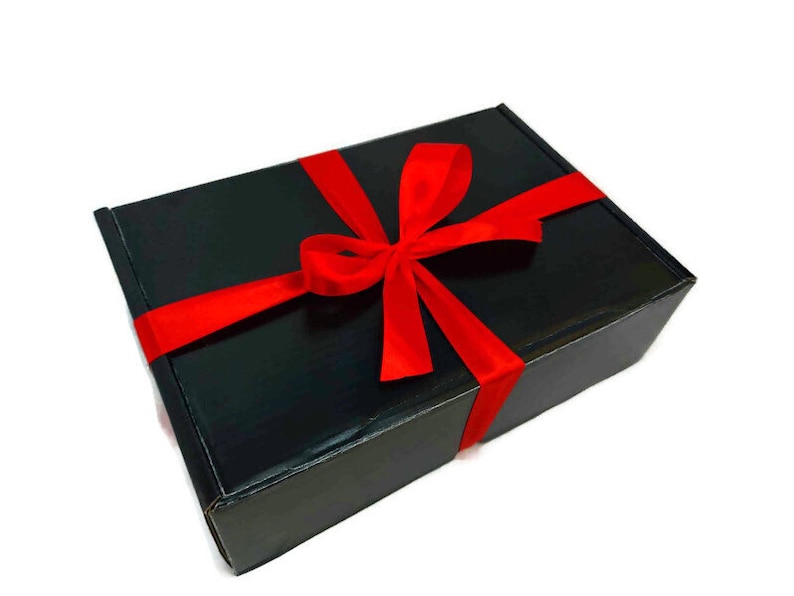 May include: A black gift box with a red ribbon tied in a bow.