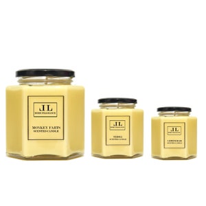 May include: Three scented candles in glass jars with black lids. The largest candle reads "Monkey Farts Scented Candle". The other two candles are labeled "Neroli Scented Candle" and "Lemongrass Scented Candle". Each candle has a yellow wax fill.