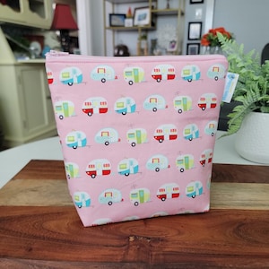 May include: Pink zippered pouch with a repeating pattern of colorful vintage camper vans.