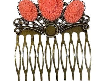 May include: A vintage-style hair comb with a bronze-colored metal base. It features three coral-colored, oval-shaped floral accents. The comb has multiple teeth for securing it in the hair.