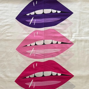 Puede incluir: Tela blanca con tres filas de labios impresos. Los labios son morados, rosas y rojos.