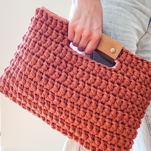 close up of chunky crochet clutch purse with leather handles