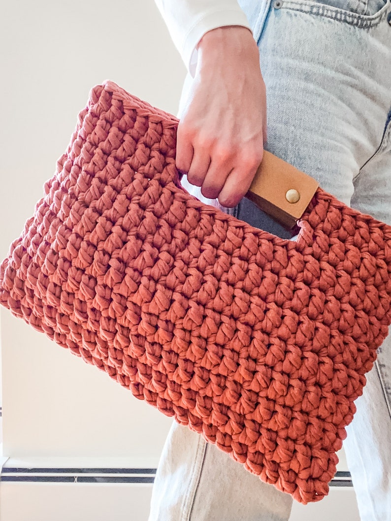 close up of chunky crochet clutch purse with leather handles