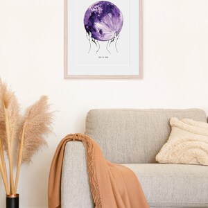May include: A framed print of a watercolor painting of a purple moon being held by two hands. The text "Take me home" is written below the moon.
