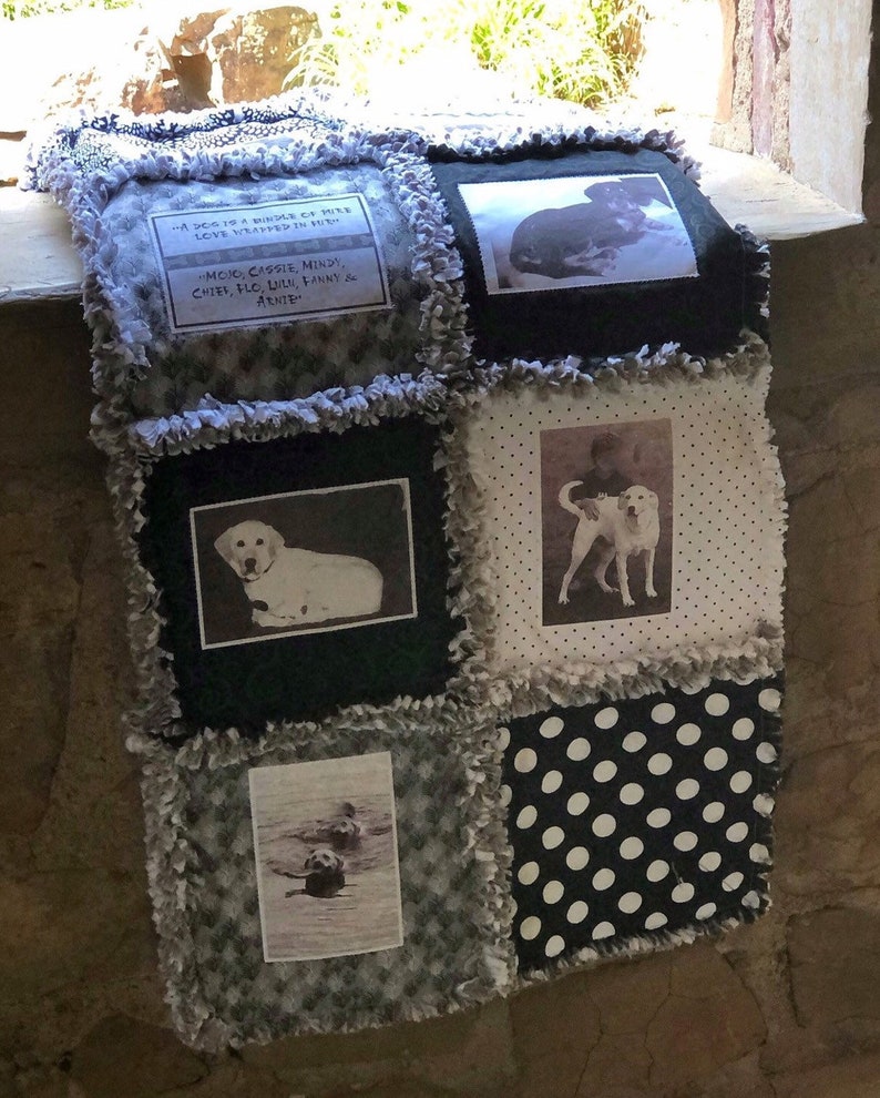 May include: A black and white quilt with a patchwork design. The quilt features photos of dogs and the text "A dog is a bundle of fur, love wrapped in fur."  "Moic, Cassie, Mindy, Chies, Flo, Liln, Fanny & Arnie"