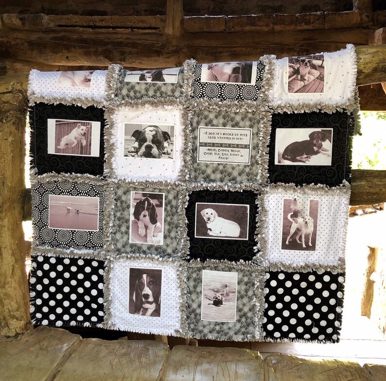 May include: A black and white quilt with a patchwork design featuring various dog photos and a quote about dogs. The quilt has a ruffled edge and is made of a soft, fuzzy fabric.