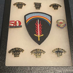 Tygmärke, nålar och displayfodral för 50-årsjubileumsdagen D