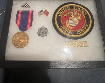 United States Marine Corps display case with medal pins and patch