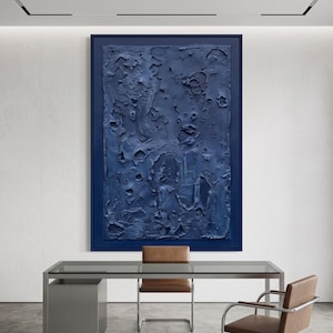 May include: A large rectangular wall art piece featuring a deep navy blue monochromatic color palette. The surface displays a heavy, raised impasto texture with irregular ridges, craters, and peaks, all encased within a matching navy blue frame.