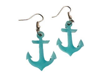 May include: A pair of turquoise blue anchor earrings with silver hooks.