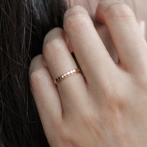 Woman wearing 14k gold filled hammered beaded ring and 14k gold filled ultra thin gold ring