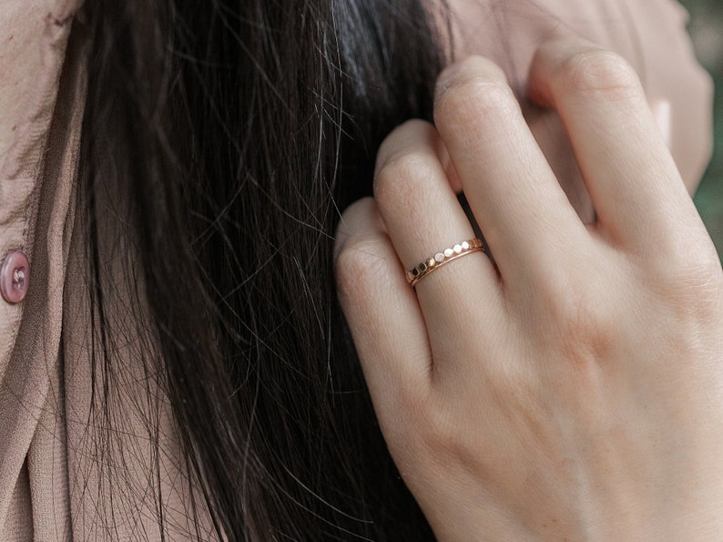 Woman wearing 14k gold filled hammered beaded ring and 14k gold filled ultra thin gold ring