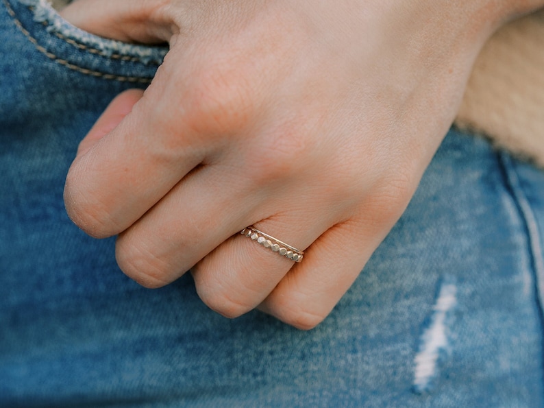 Woman wearing 14k gold filled ultra thin rings and various other Laurel Elaine Jewelry