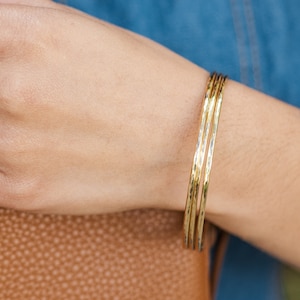 Woman wearing thick gold bangles