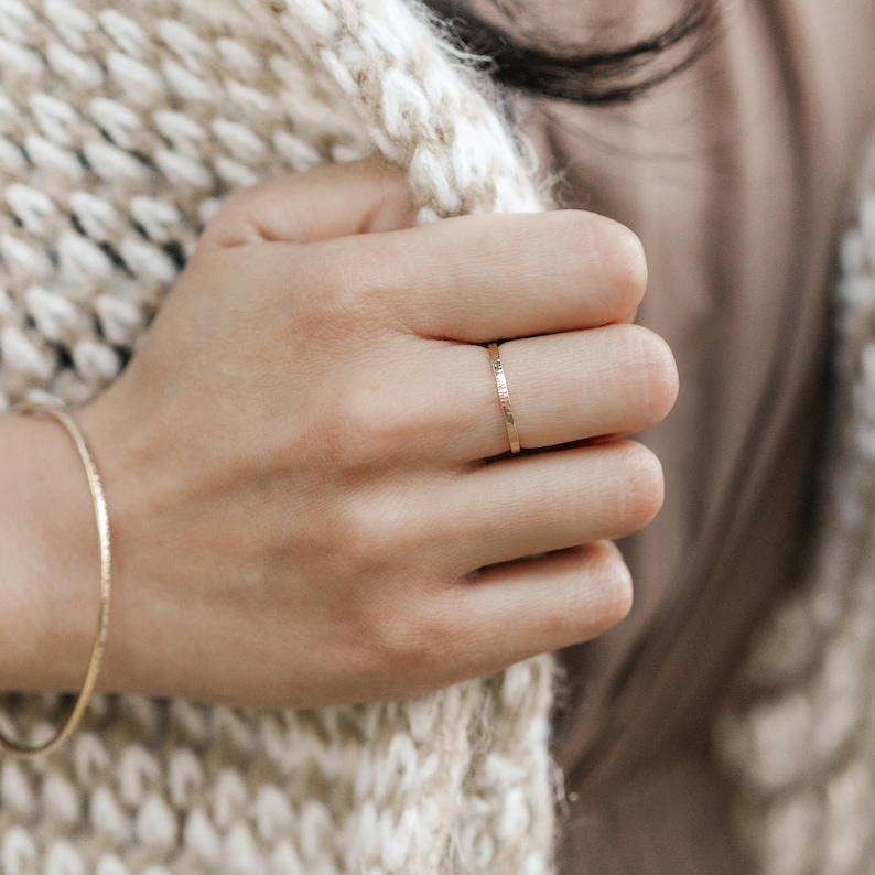 Woman wearing 14k gold filled thick sparkle ring and various other Laurel Elaine Jewelry