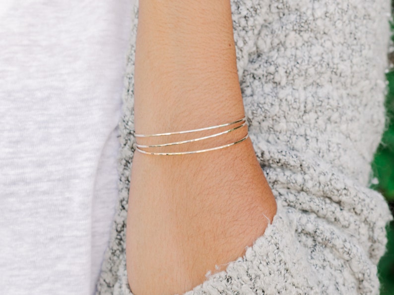 Woman wearing a set of three 14k gold filled bangles