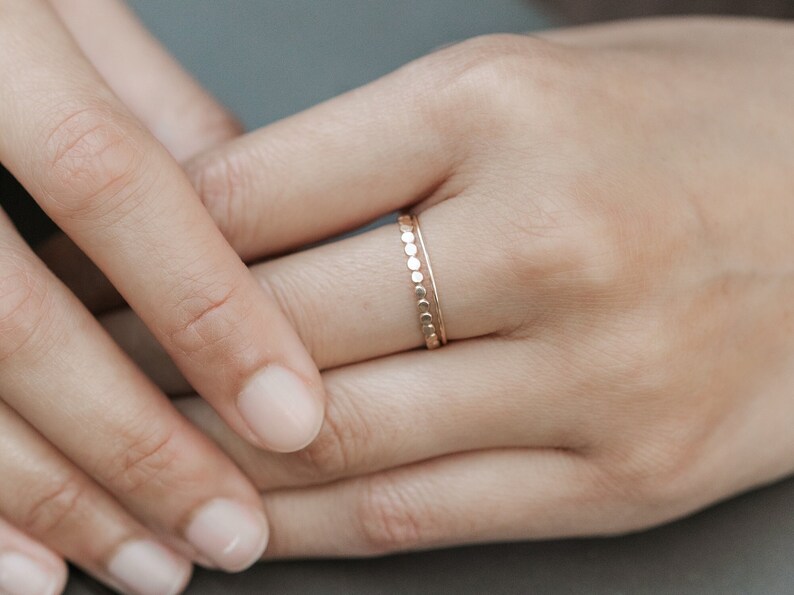 Woman wearing 14k gold filled ultra thin rings and various other Laurel Elaine Jewelry