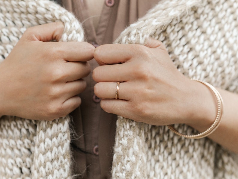 Woman wearing 14k gold filled hammered beaded ring and 14k gold filled ultra thin gold ring and various other Laurel Elaine Jewelry