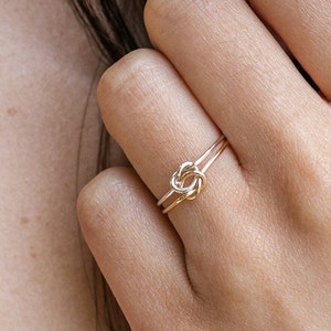 Woman wearing 14k gold filled and sterling silver interlocking double knot ring