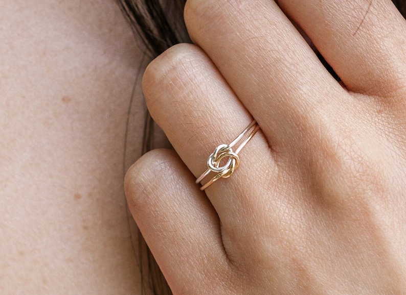 Woman wearing 14k gold filled and sterling silver interlocking double knot ring