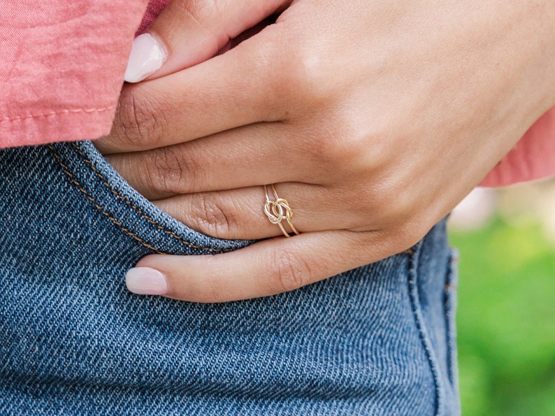 Woman wearing 14k gold filled and sterling silver interlocking double knot ring