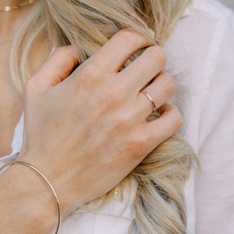 Woman wearing 14k gold filled thick sparkle ring and various other Laurel Elaine Jewelry