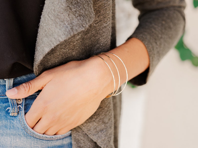 Woman wearing a set of three 14k gold filled bangles